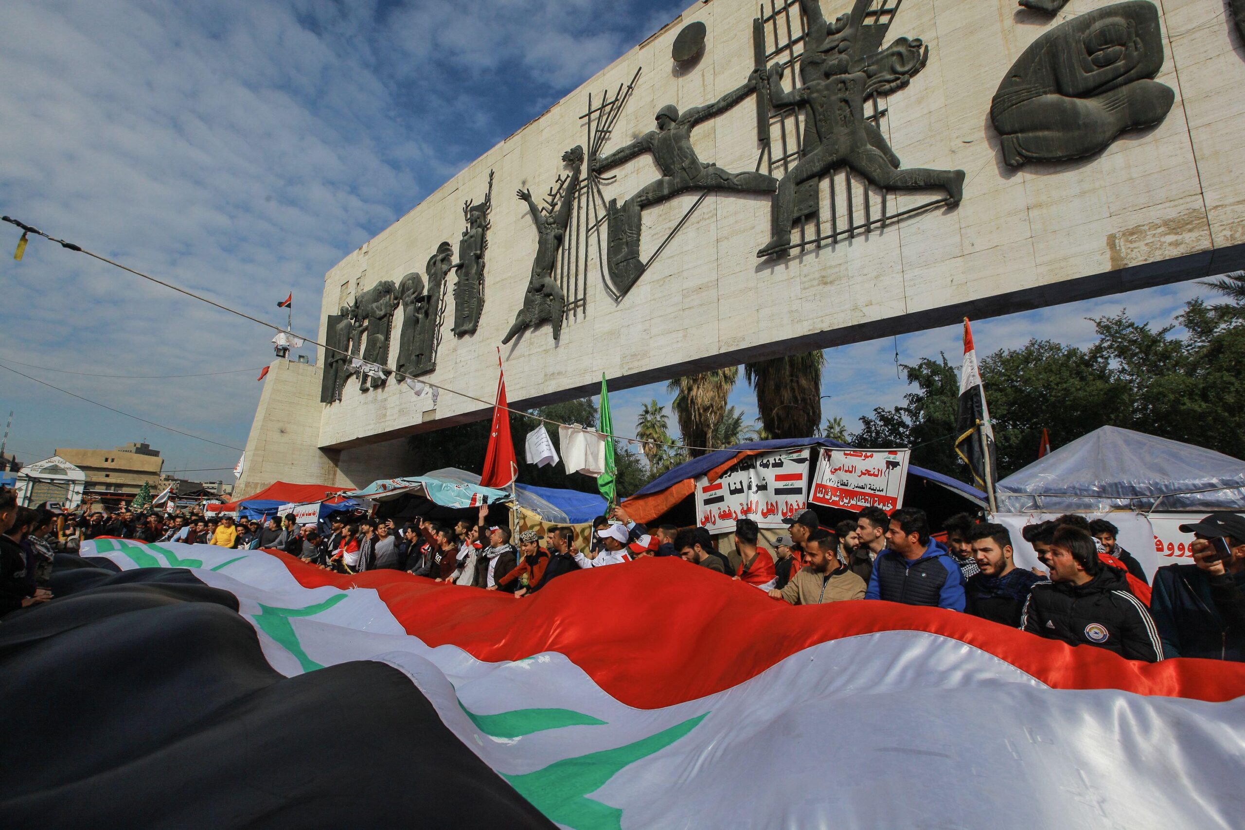 Baghdad, Iraq. 10th Jan, 2020. Anti-government demonstrators wave a huge Iraqi national flag during a demonstration in Tahrir square, against the breach of Iraqi sovereignty by the US and Iran. Credit: Ameer Al Mohammedaw/dpa/Alamy Live News.
