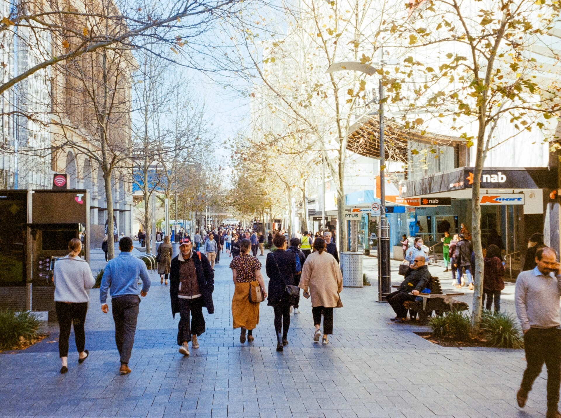 Photograph of people walking through the city streets of Canberra on a sunny day.