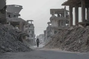 Lone figure walks through the rubble of war in the Middle East
